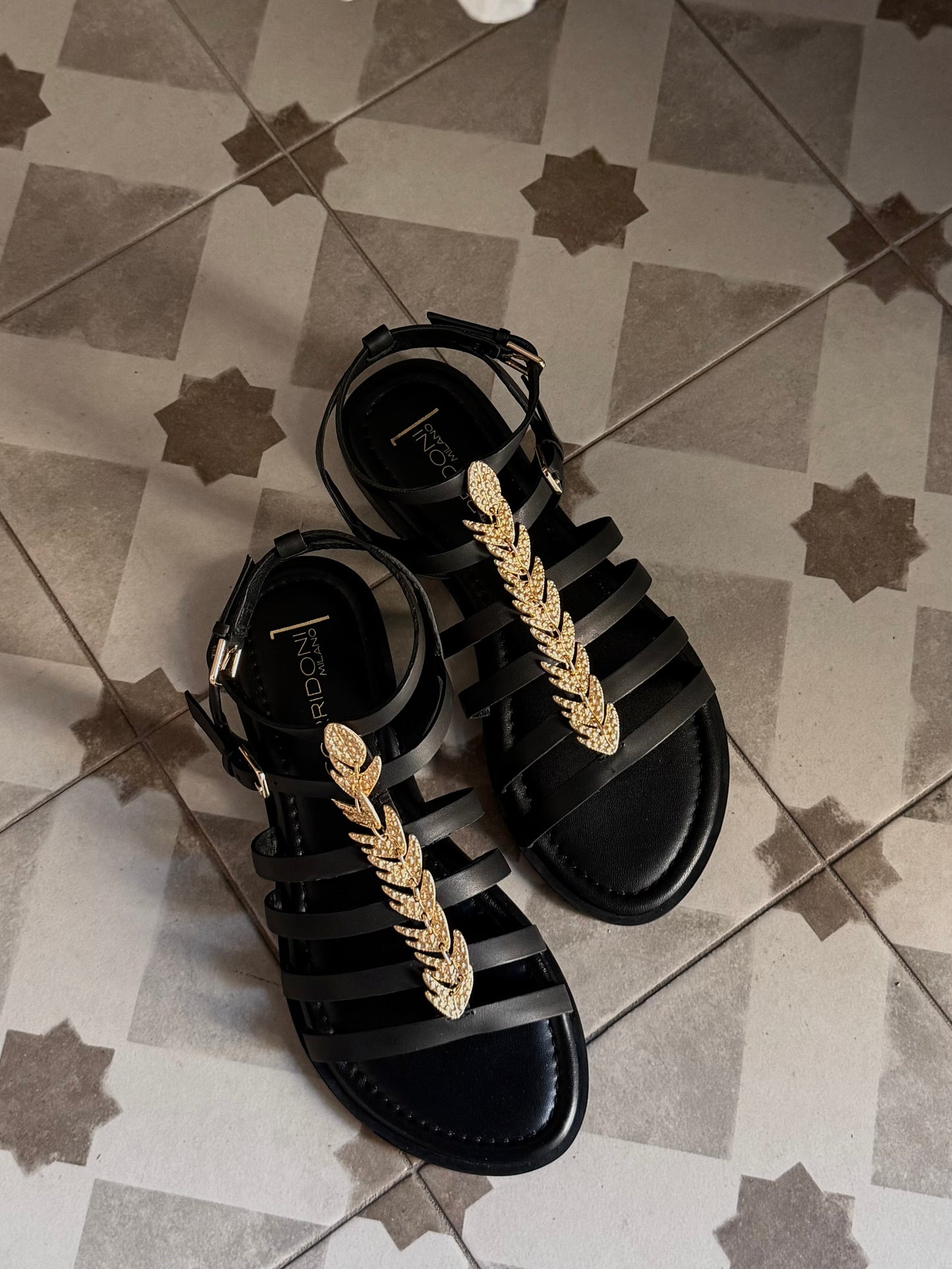 Sandalo in pelle con listini e accessorio oro