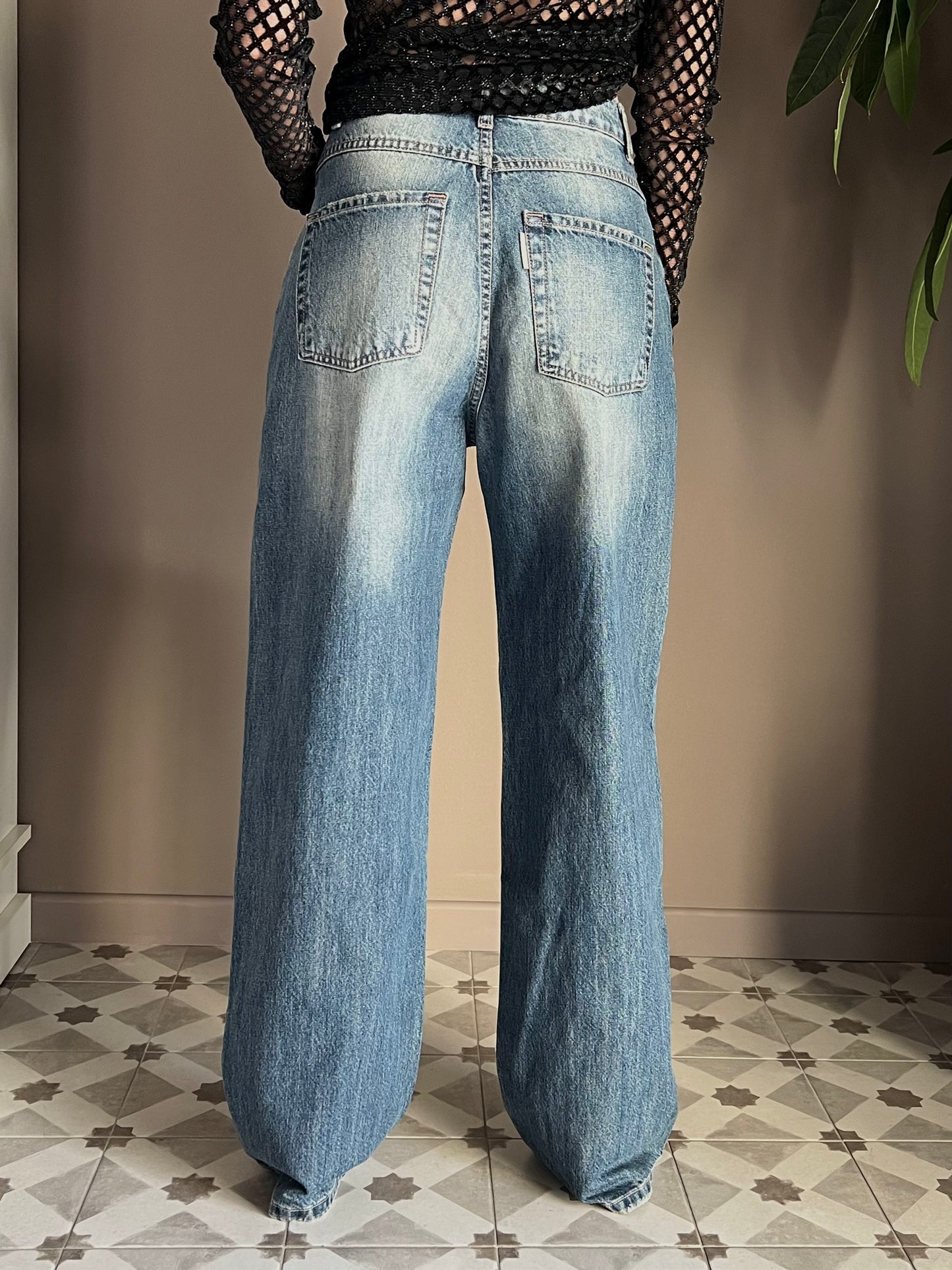 Pantalone in denim con strappo sul fondo